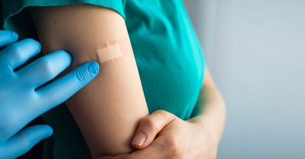 Delightful Image of woman with a bandage on her right arm after receiving a vaccine