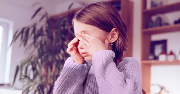 Young girl rubbing her eye's because they are itchy from a pink eye infection